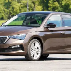 Brązowa Skoda Scala z czarnym dachem, zaparkowana na zewnątrz.