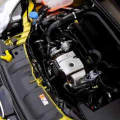 Silnik 1.0 Ecoboost w żółtym Fordzie. Widoczne elementy układu dolotowego, turbosprężarki i osłony silnika.