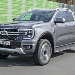 Szary Ford Ranger Platinum, jeden z najnowszych ford modele, jedzie po drodze.
