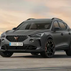 Stylowe, ciemnoszare auto Cupra z miedzianymi akcentami na felgach, zaparkowane na pustkowiu o zachodzie słońca.