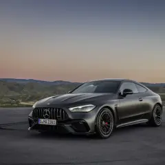 Mroczny Mercedes-AMG CLE 53 coupe na tle górskiego krajobrazu o zachodzie słońca.