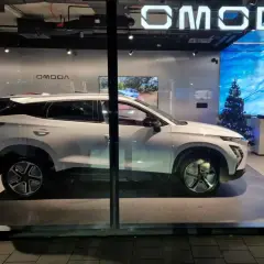Biały OMODA w salonie, obok choinka. Nowe polskie marki samochodów wkraczają na rynek.