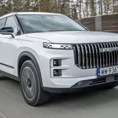 Biały Jaecoo 7 w ruchu, z charakterystycznym grillem i światłami LED. Sprawdź jego atrakcyjną jaecoo 7 cenę!