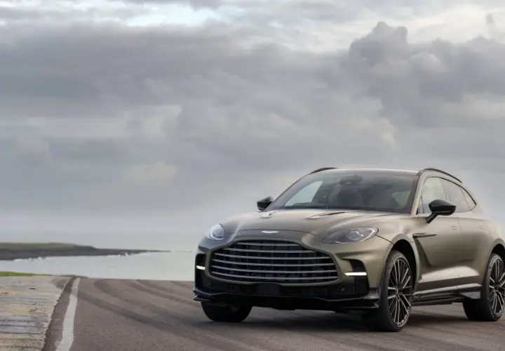 Aston Martin DBX 707 na tle pochmurnego nieba i morza. Luksusowy SUV prezentuje się majestatycznie na pustej drodze.