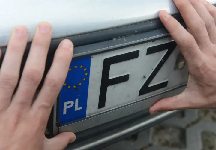 DSR rejestracja. Dwie dłonie trzymają polską tablicę rejestracyjną z literami FZ.