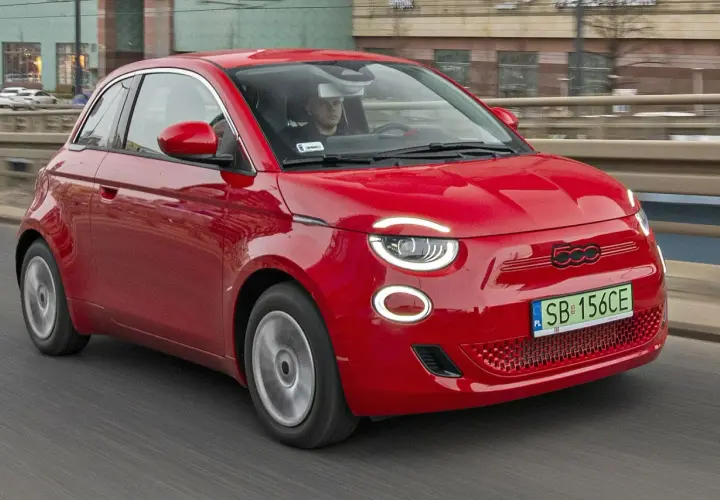 Czerwony Fiat 500 jedzie po drodze. Sprawdź aktualną fiat 500 cena i wybierz swój wymarzony model!