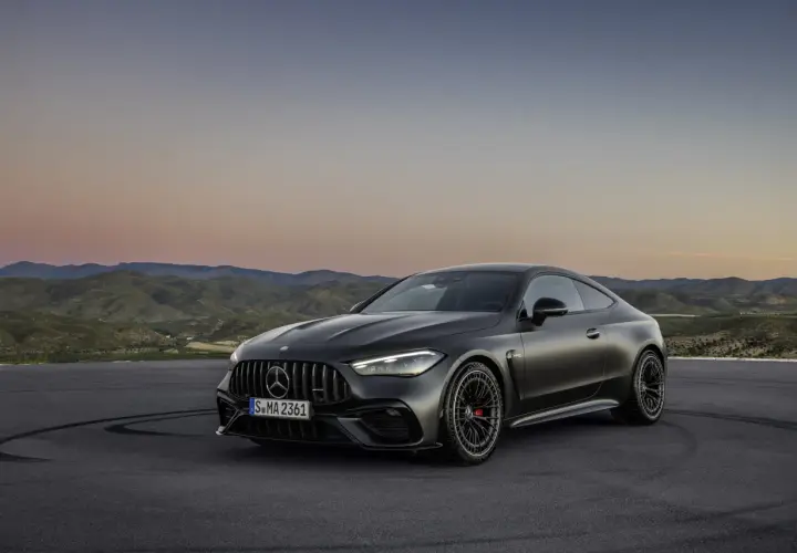 Mroczny Mercedes-AMG CLE 53 coupe na tle górskiego krajobrazu o zachodzie słońca.