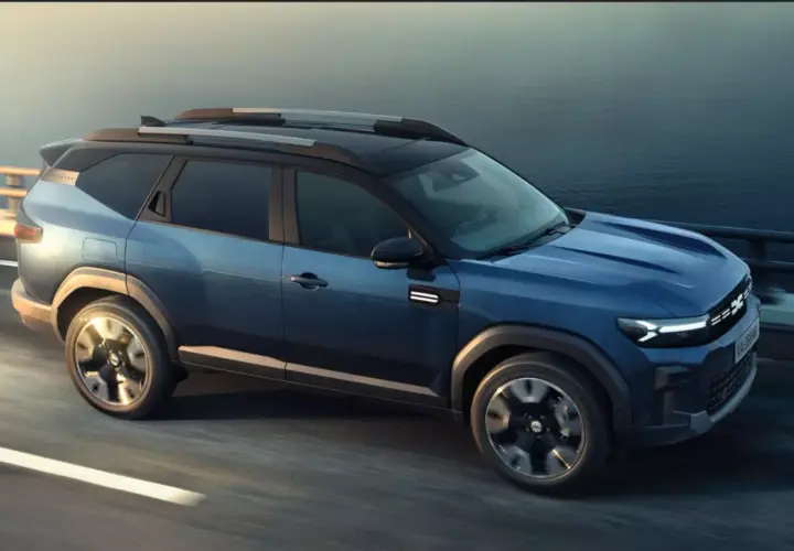 Niebieski Dacia Bigster 2025 na drodze, z nowoczesnym designem i relingami dachowymi.