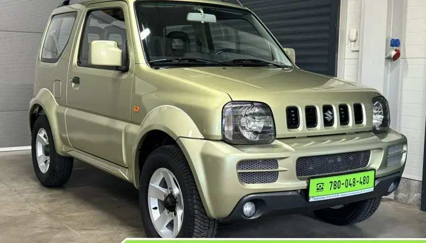 Złoty Suzuki Jimny 4x4 stoi w garażu. Idealny do terenu, ten kompaktowy SUV czeka na przygodę.