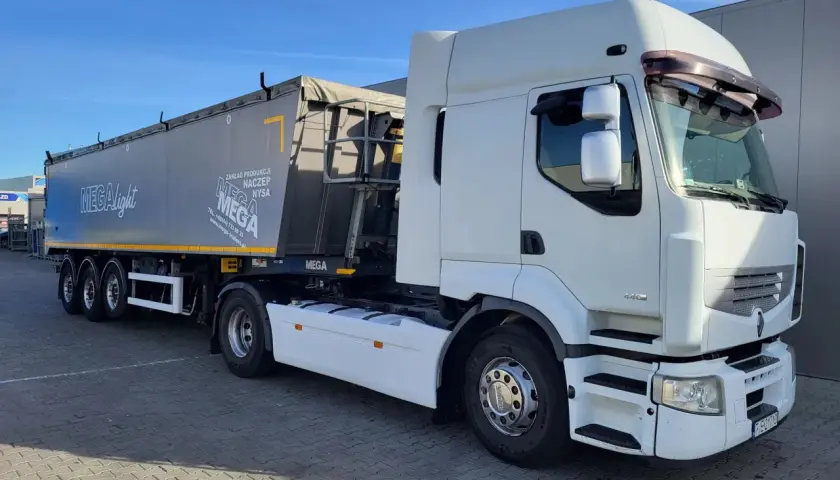 Biała ciężarówka Renault Premium z naczepą MEGA, gotowa do trasy.