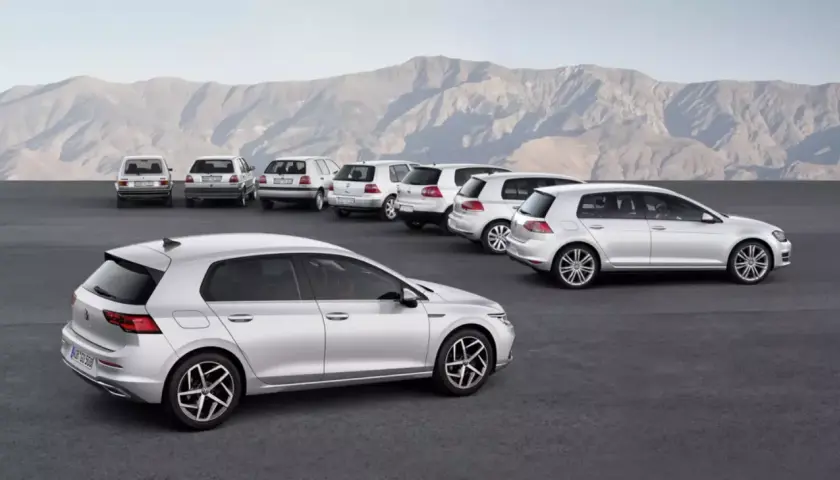 Ewolucja modelu golf 9. Rząd srebrnych samochodów, od klasycznych po nowoczesne, na tle gór.