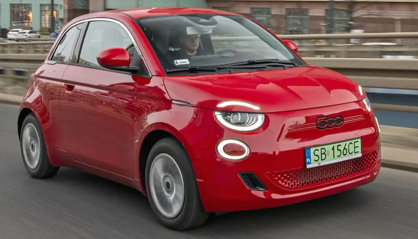 Czerwony Fiat 500 jedzie po drodze. Sprawdź aktualną fiat 500 cena i wybierz swój wymarzony model!