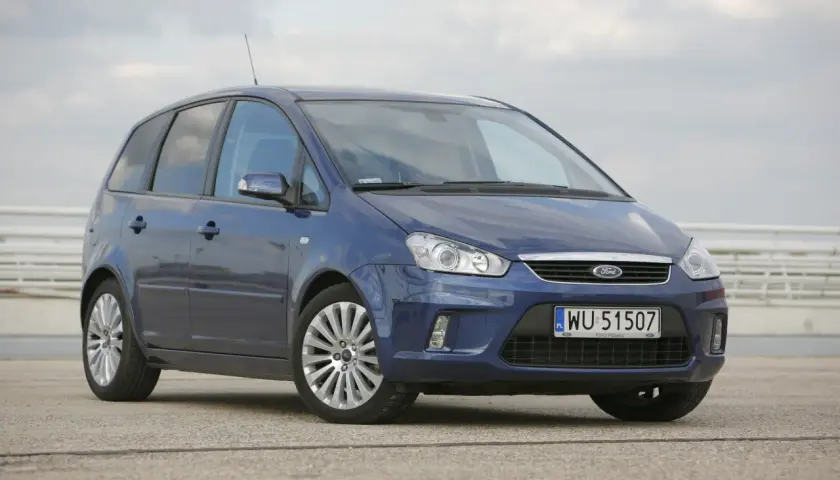 Niebieski Ford C-Max 1.6 benzyna z polskimi tablicami WU 51507 zaparkowany na betonowym placu.