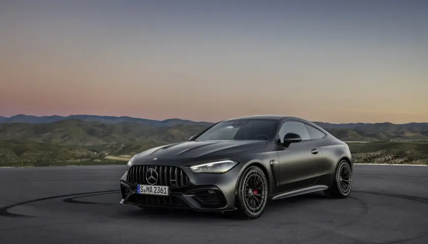 Mroczny Mercedes-AMG CLE 53 coupe na tle górskiego krajobrazu o zachodzie słońca.