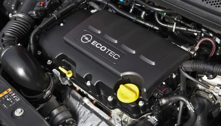 Silnik ECOTEC w Opel Astra J 1.4 Turbo. Widoczne elementy układu dolotowego i osłona silnika.