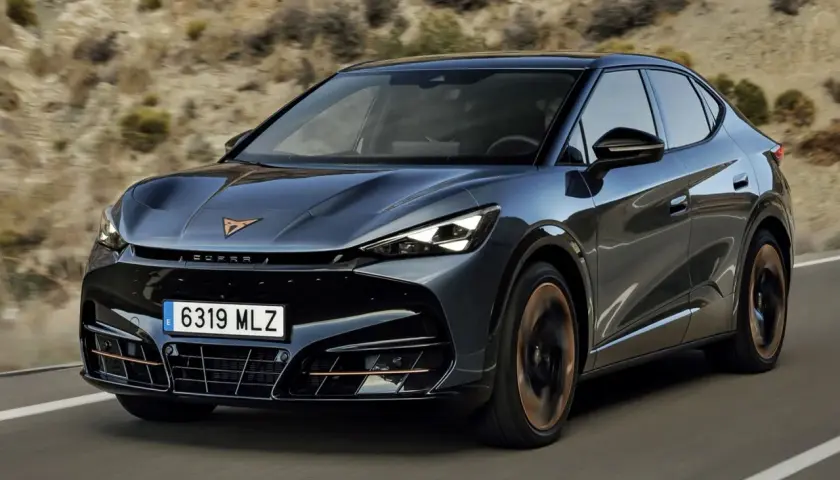 Ciemnoszary Cupra Tavascan jedzie po drodze. Sprawdź aktualną cupra tavascan cena i dowiedz się więcej o tym stylowym SUV-ie coupe.